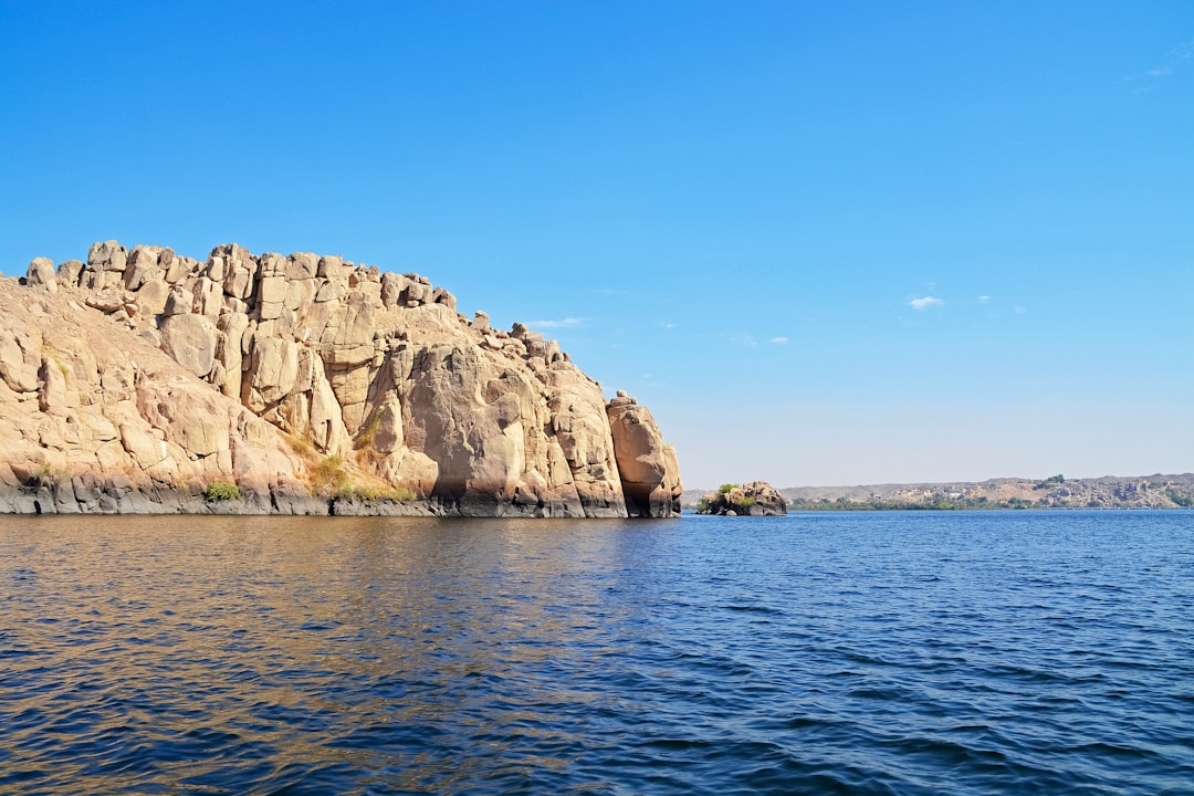 brown rock formation on sea under blue sky during daytime