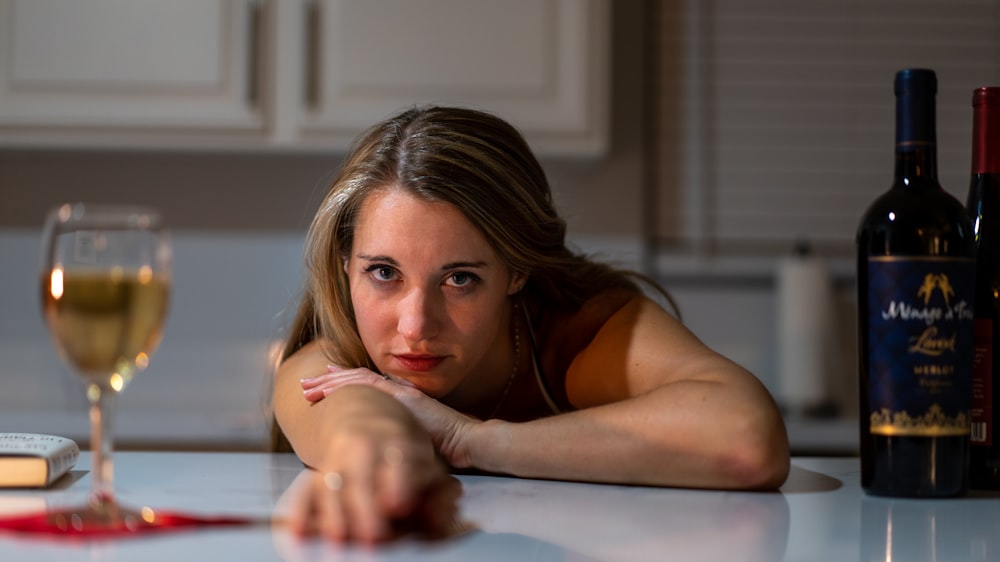 femme en débardeur noir allongée sur un lit blanc