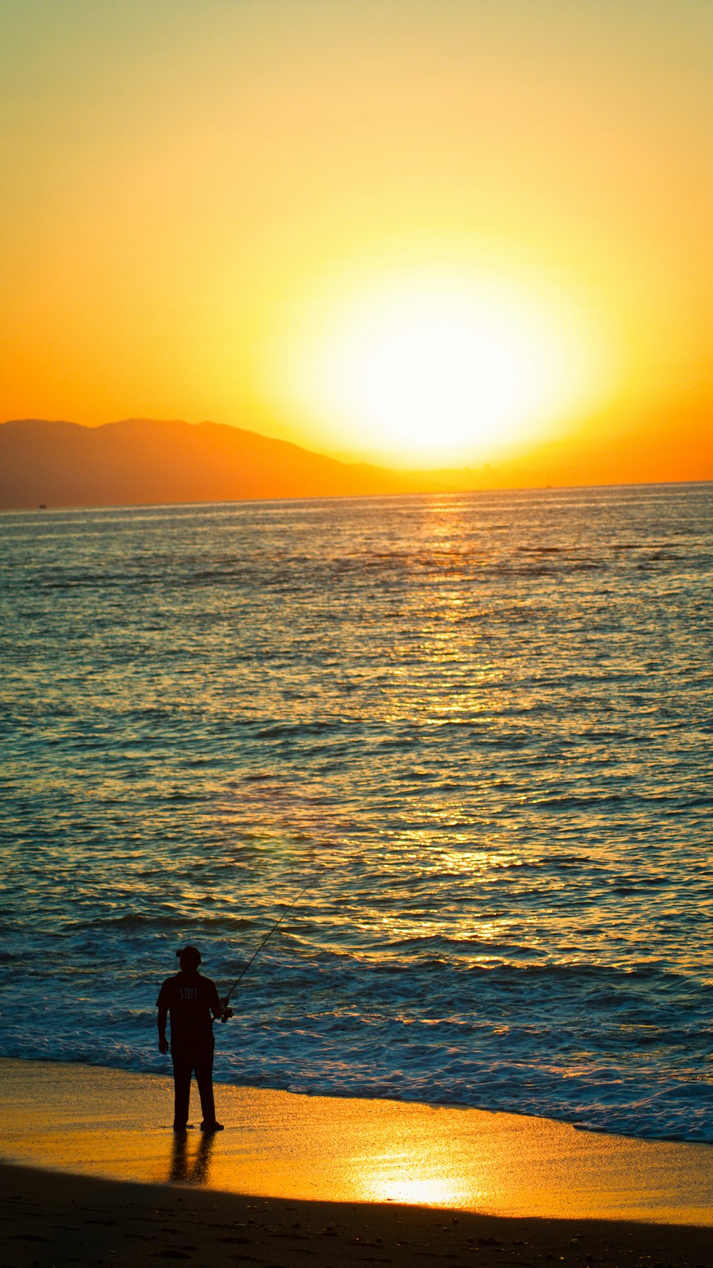silhouette de personne sur le plan d’eau au coucher du soleil