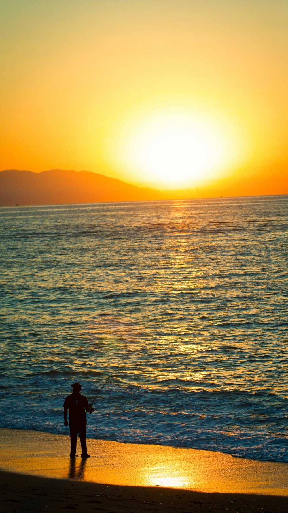 silhouette of person on body of water during sunset