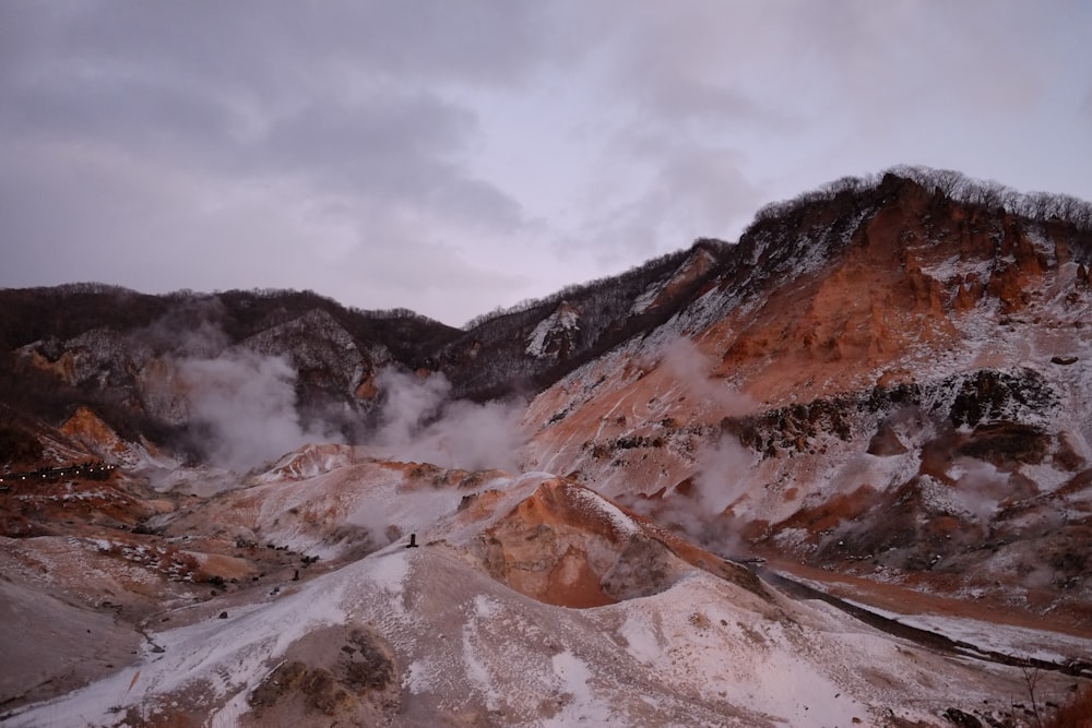 brown and white mountain under white clouds during daytime