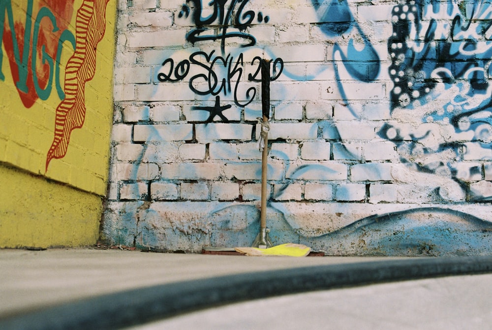 black metal fence beside wall with graffiti