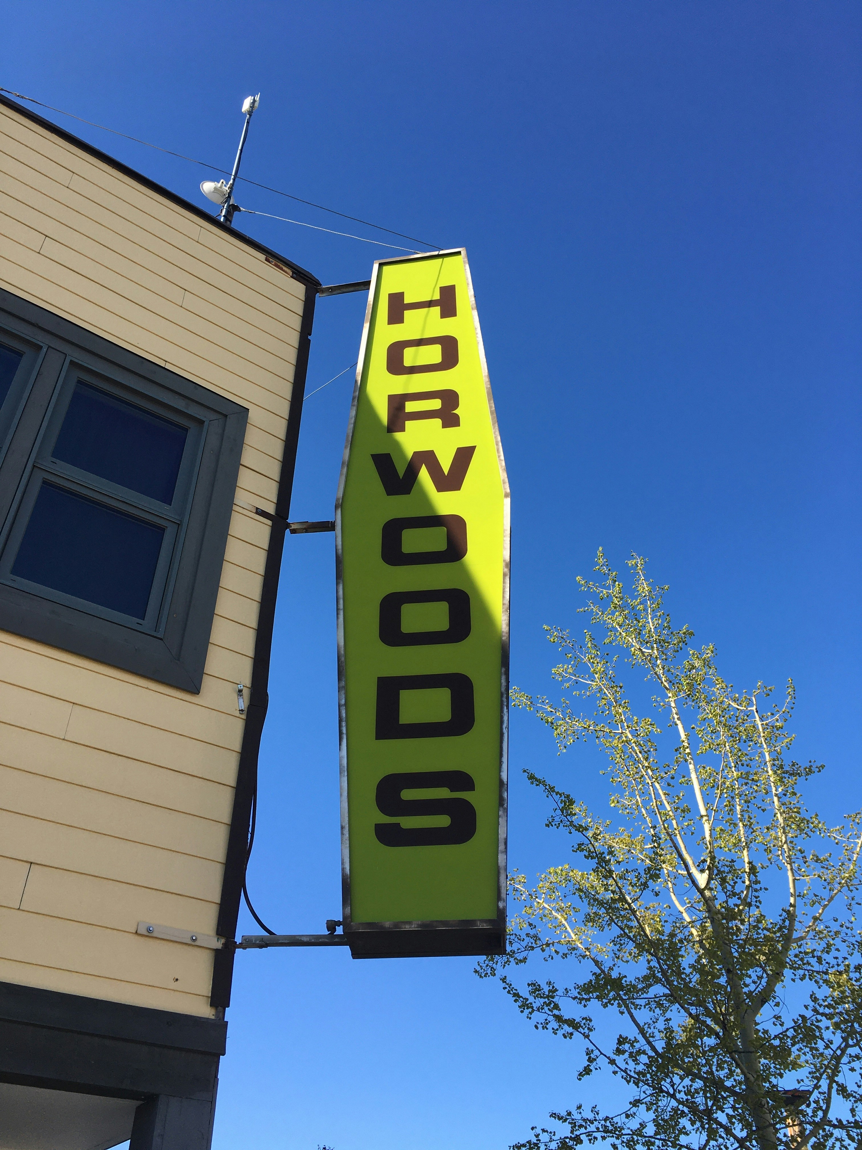 a yellow sign hanging from the side of a building