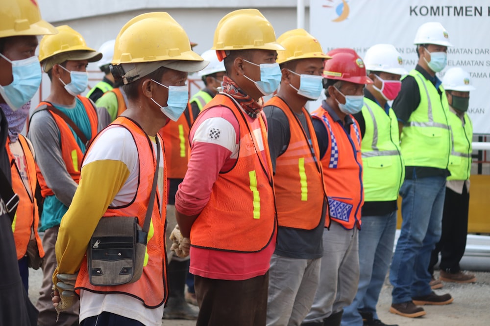 Grupo de personas con chaleco de seguridad naranja y amarillo