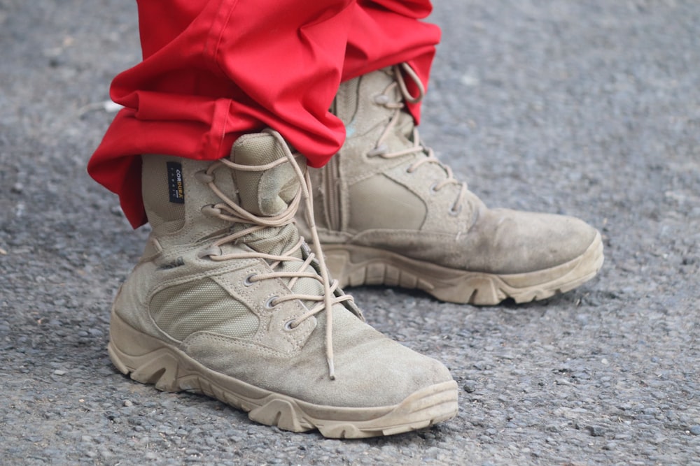 person in red pants and brown leather lace up boots