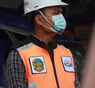 man in orange vest wearing white helmet