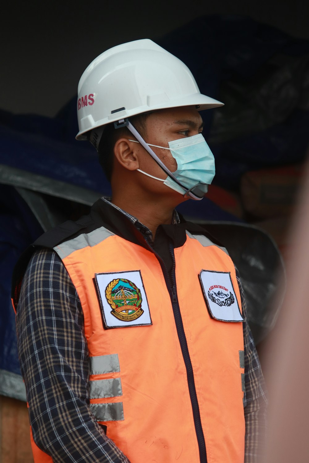 man in orange vest wearing white helmet