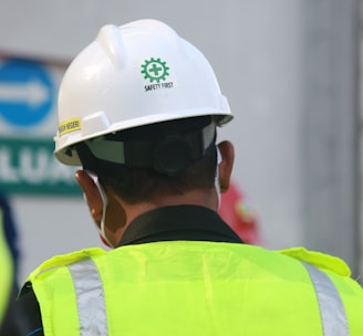 man in yellow and black vest wearing white helmet