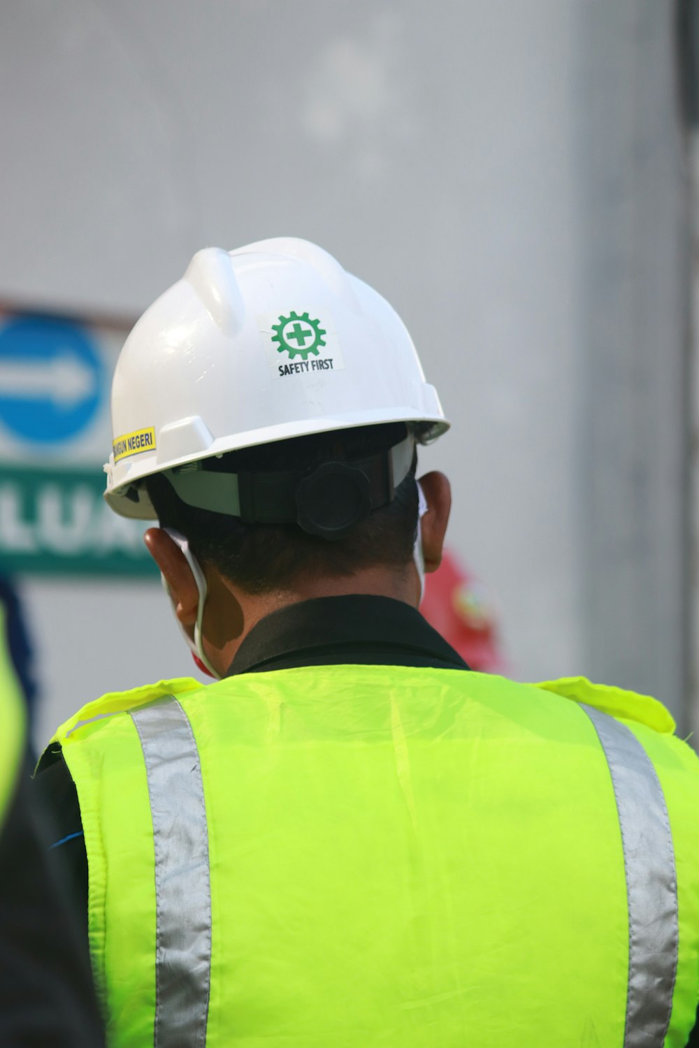 Homme en gilet jaune et noir portant un casque blanc