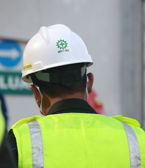 man in yellow and black vest wearing white helmet