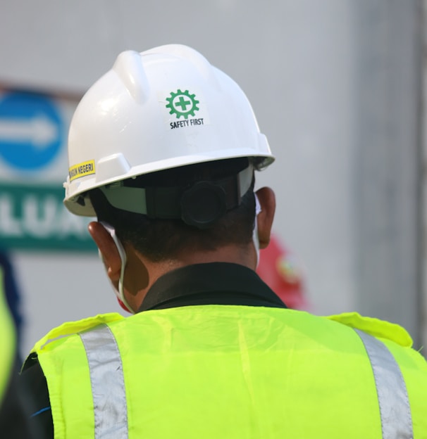 man in yellow and black vest wearing white helmet