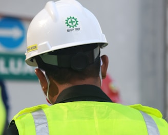 man in yellow and black vest wearing white helmet