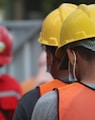 man in orange helmet and black jacket