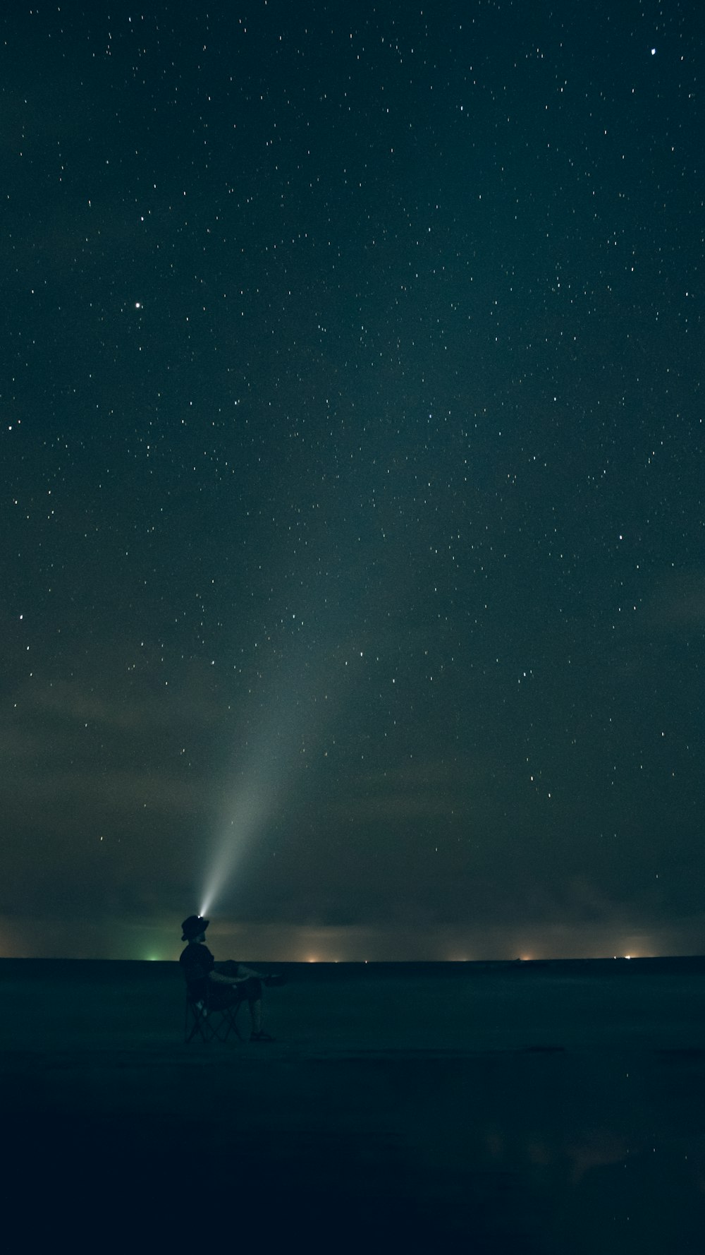 silhouette of man standing on the ground under starry night