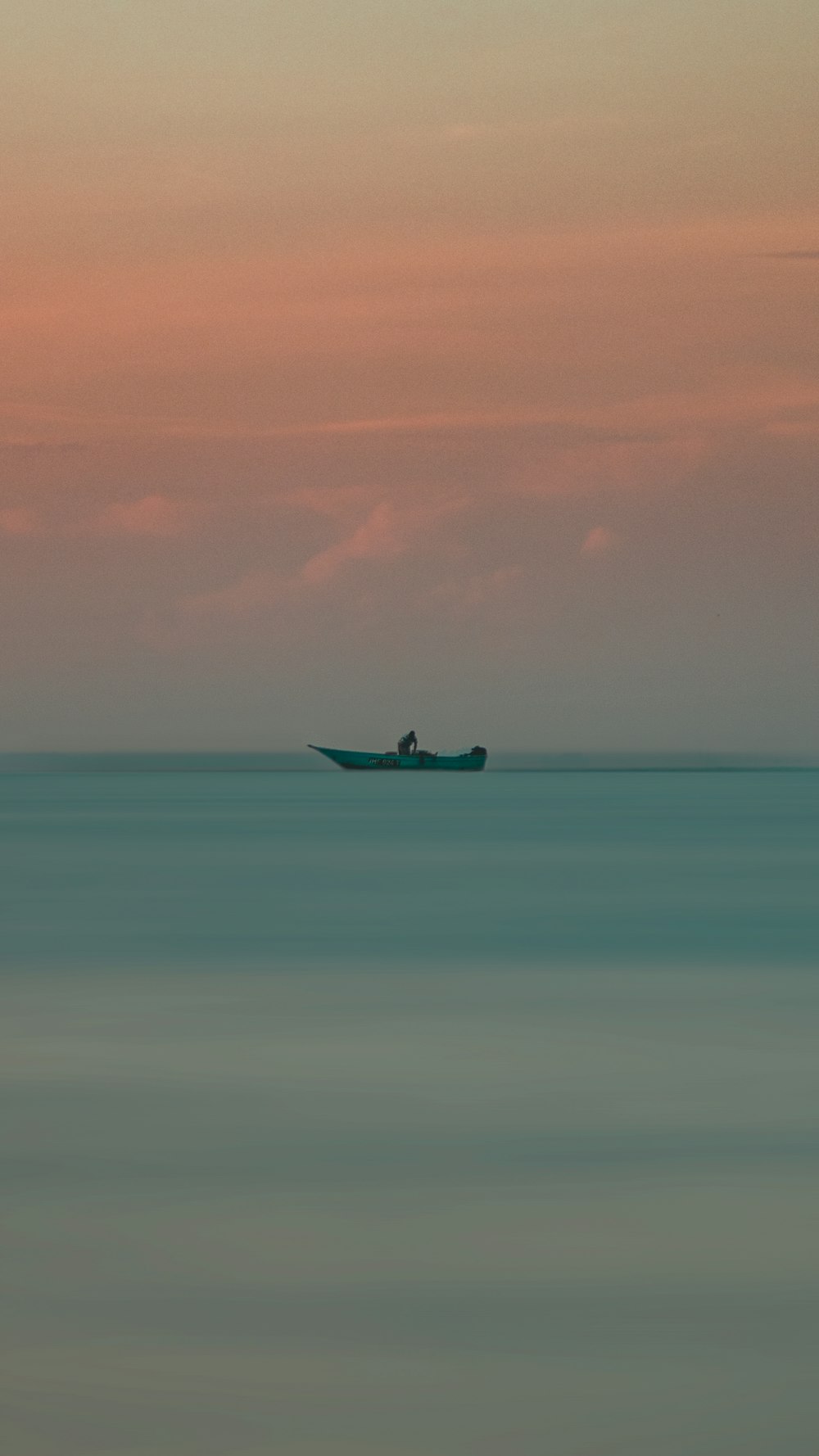 black boat on sea under white sky during daytime