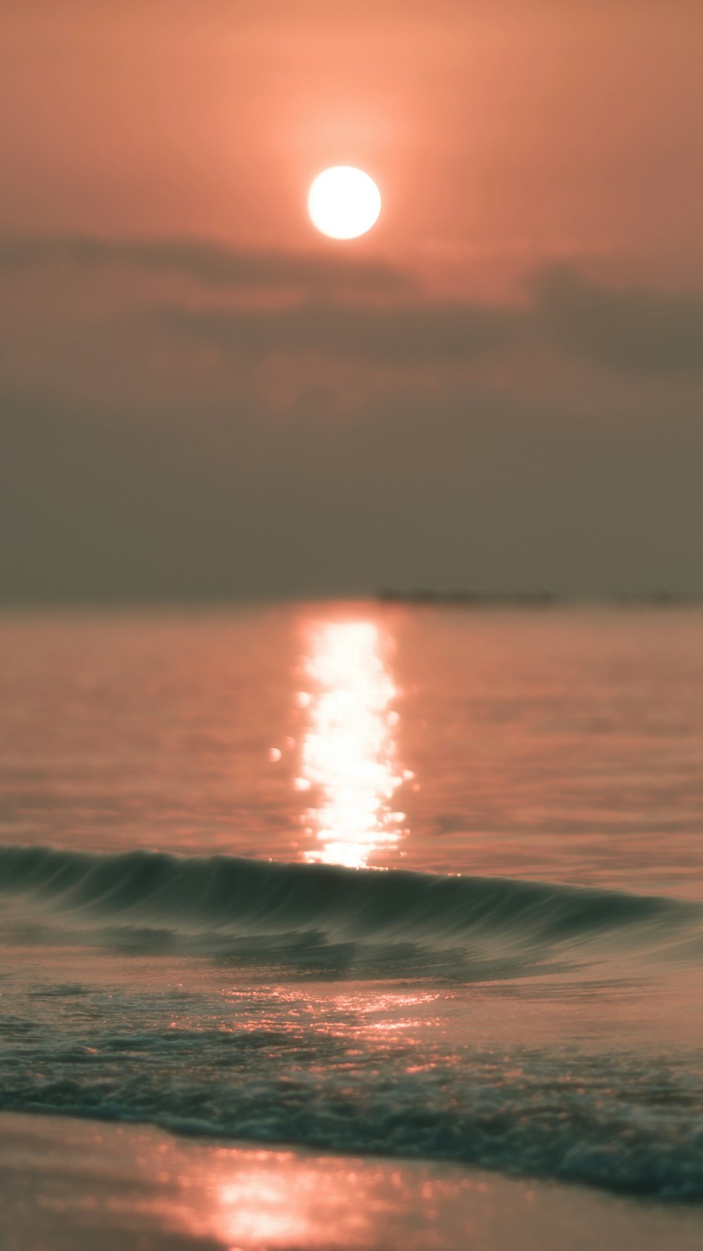 ocean waves under gray sky during sunset
