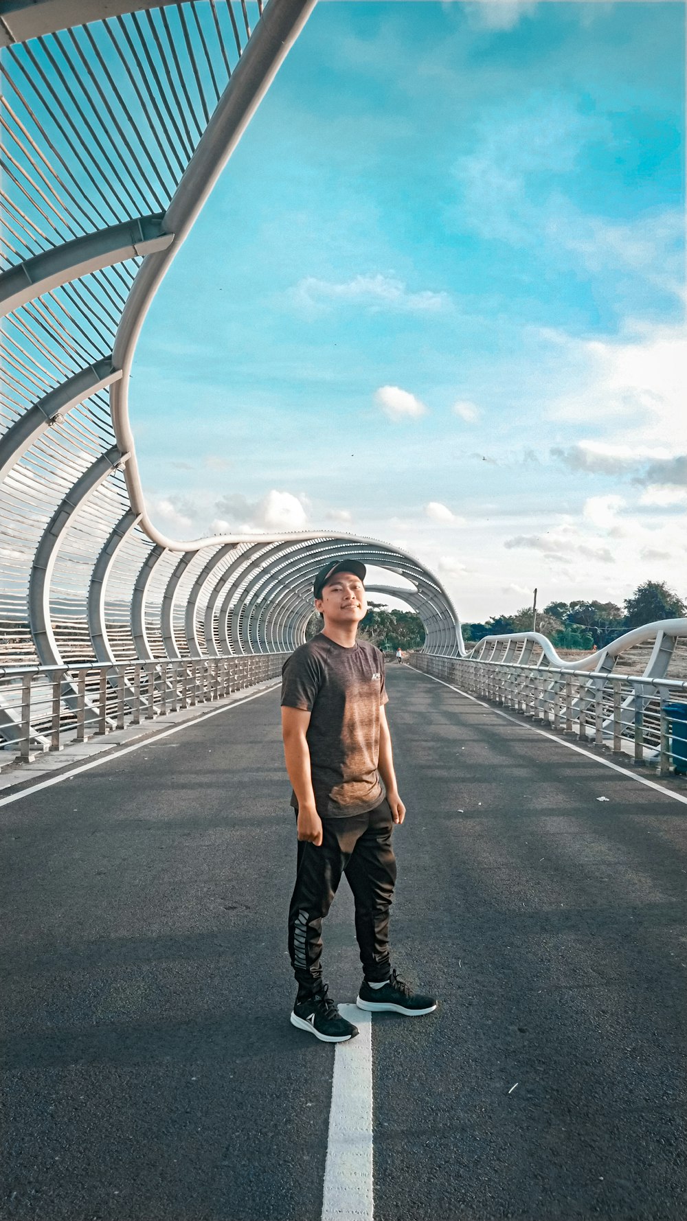 woman in brown jacket standing on gray concrete bridge during daytime