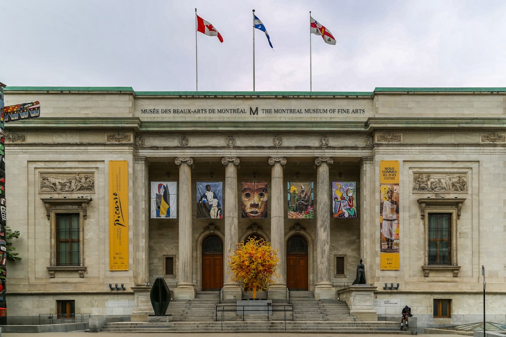 beige concrete building with flags on top during daytime