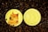 Two gold-colored coins placed on a bed of dark gravel. One coin features a popular meme dog with the word 'WOW' and humorous text around the border. The other coin displays a large 'D' symbol, labeled as '1 DOGECOIN'.