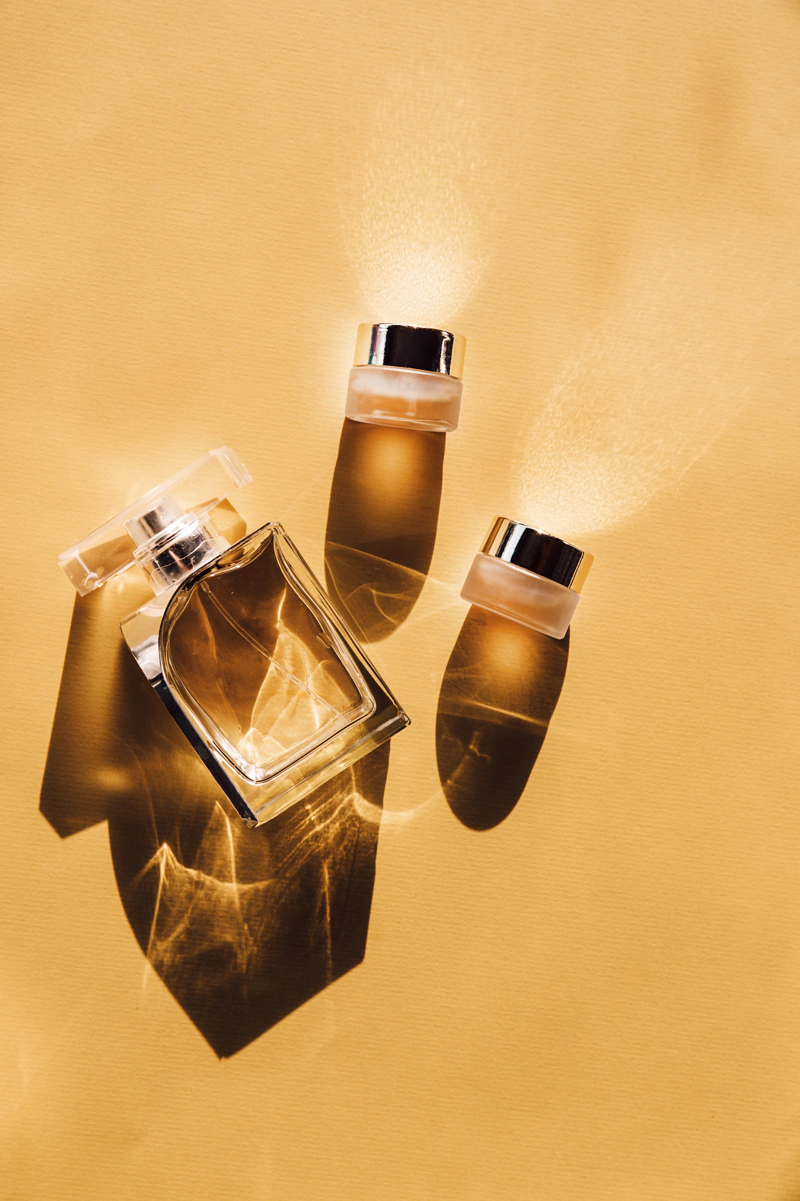 Golden perfume bottles suspended in light