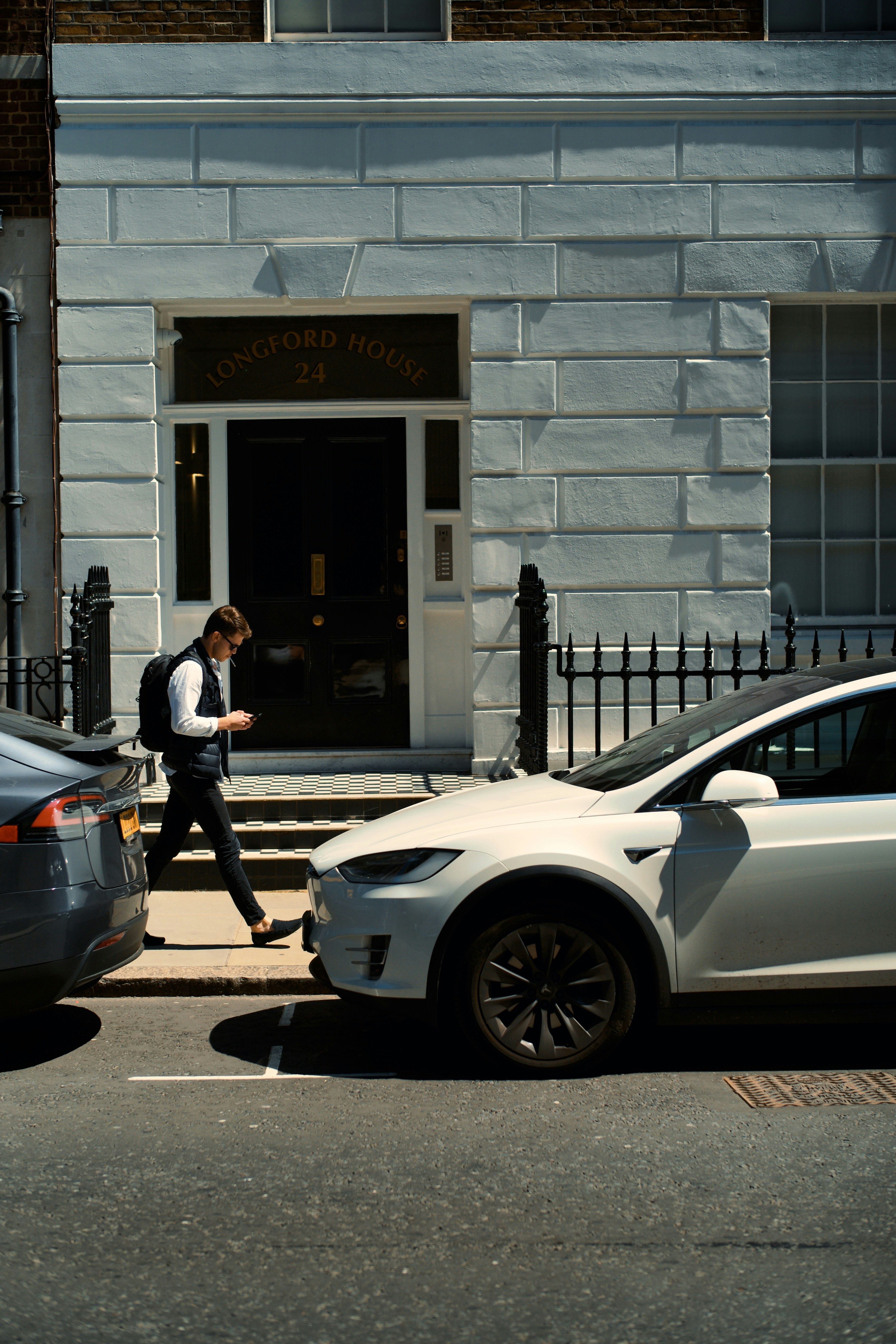 woman in black jacket and black pants standing beside white car during daytime