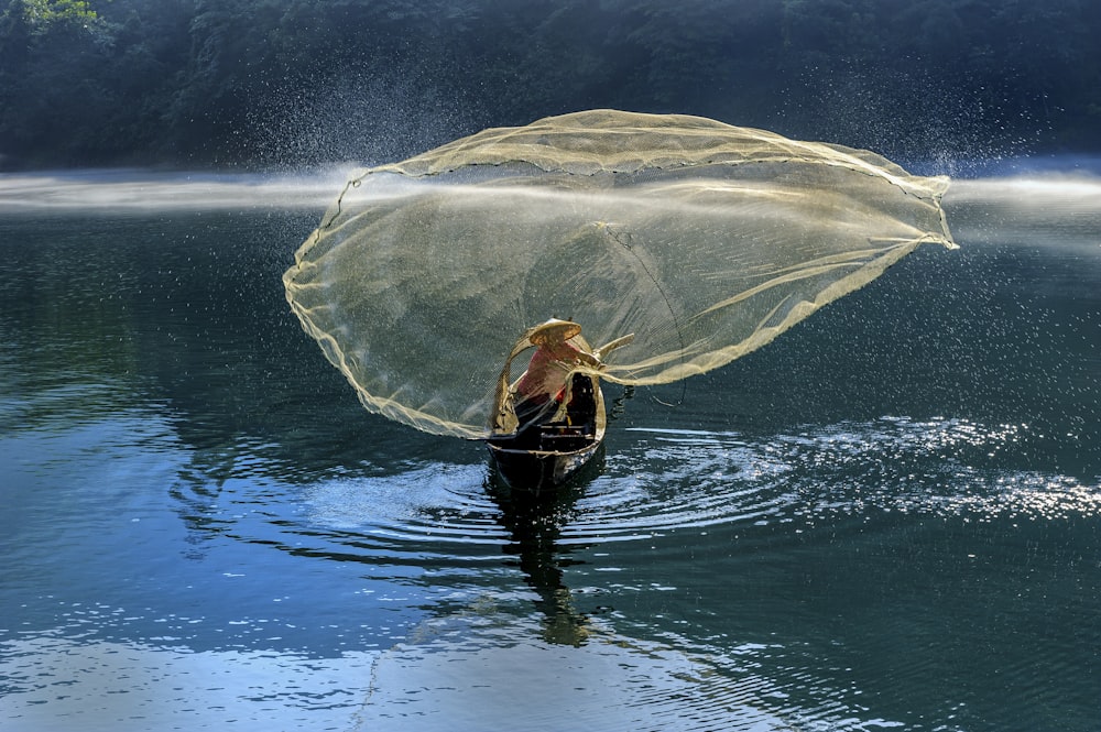 person in black wet suit holding white textile