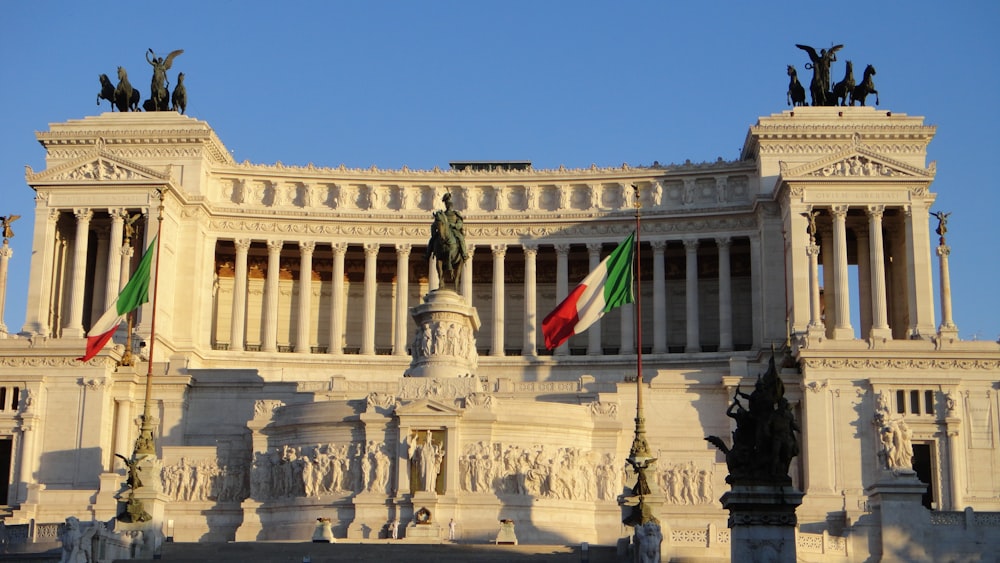 white concrete building with flags during daytime