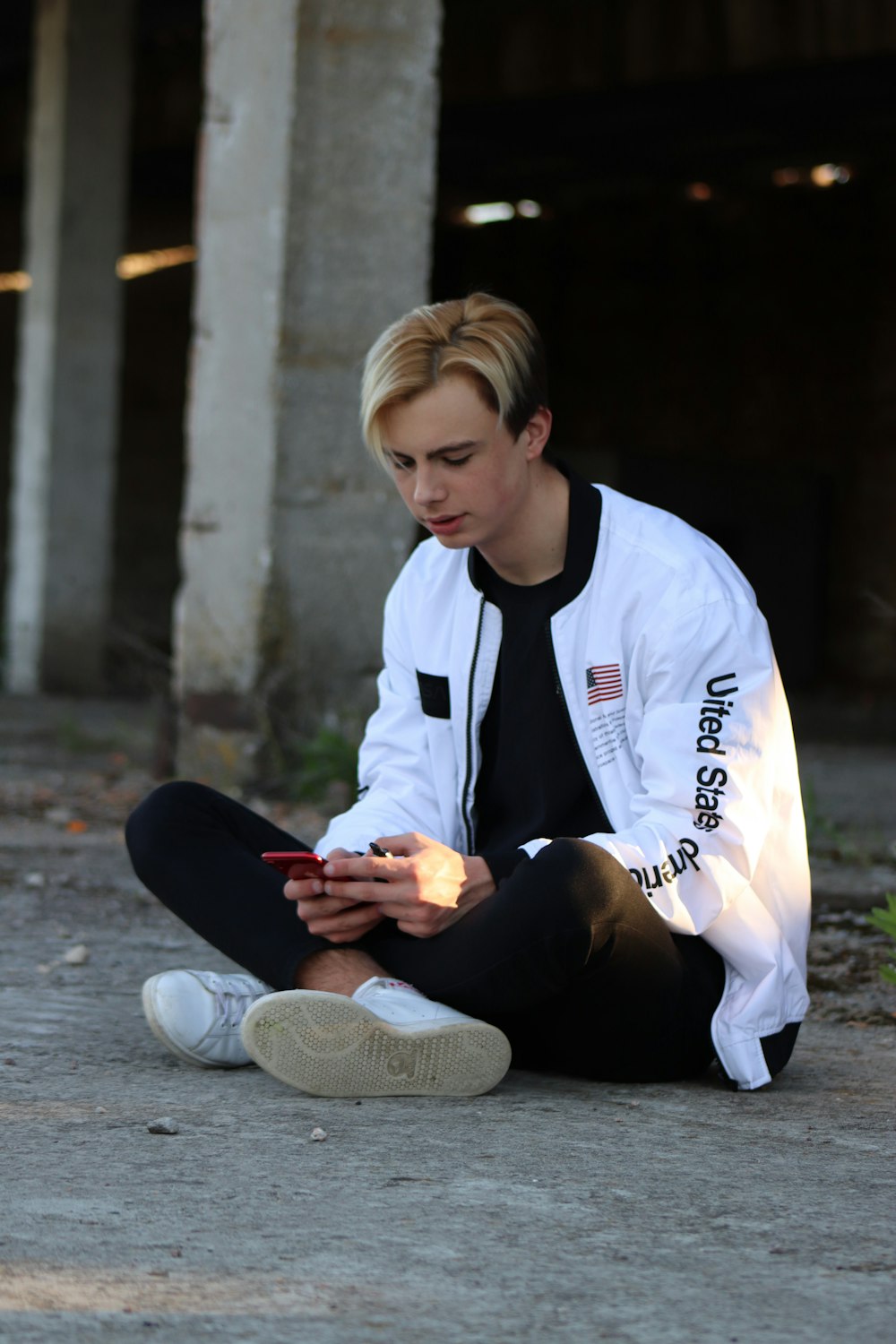 girl in white and blue crew neck t-shirt and black pants sitting on ground