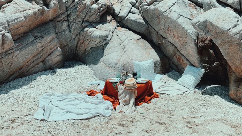 donna in abito bianco e rosso che si siede su sabbia bianca durante il giorno