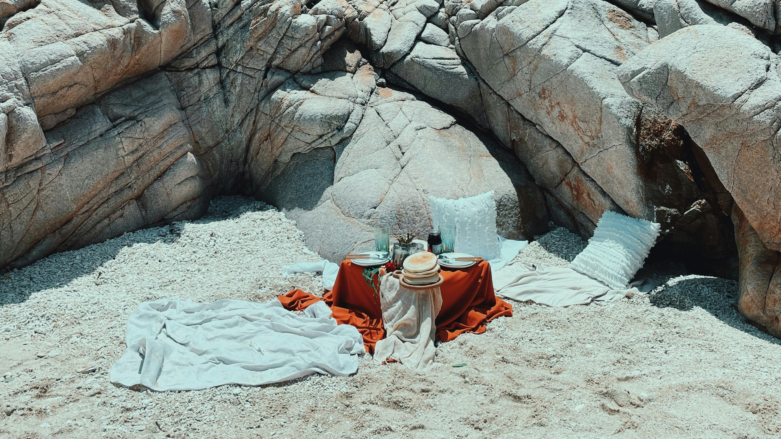 woman in white and red dress sitting on white sand during daytime