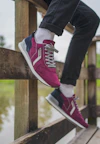 person wearing pink and white converse all star high top sneakers