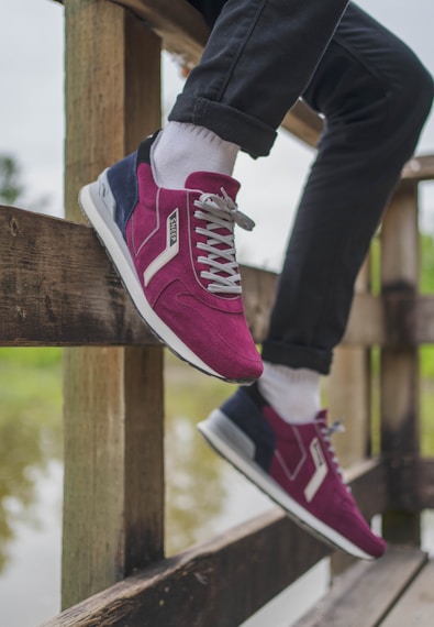 person wearing pink and white converse all star high top sneakers