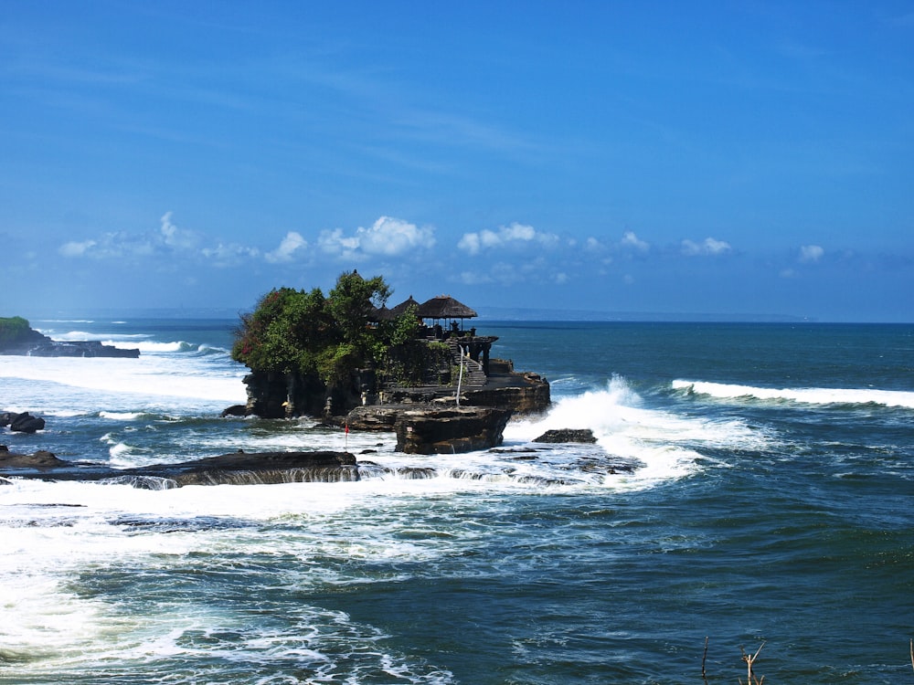 green trees on island surrounded by water under blue sky during daytime