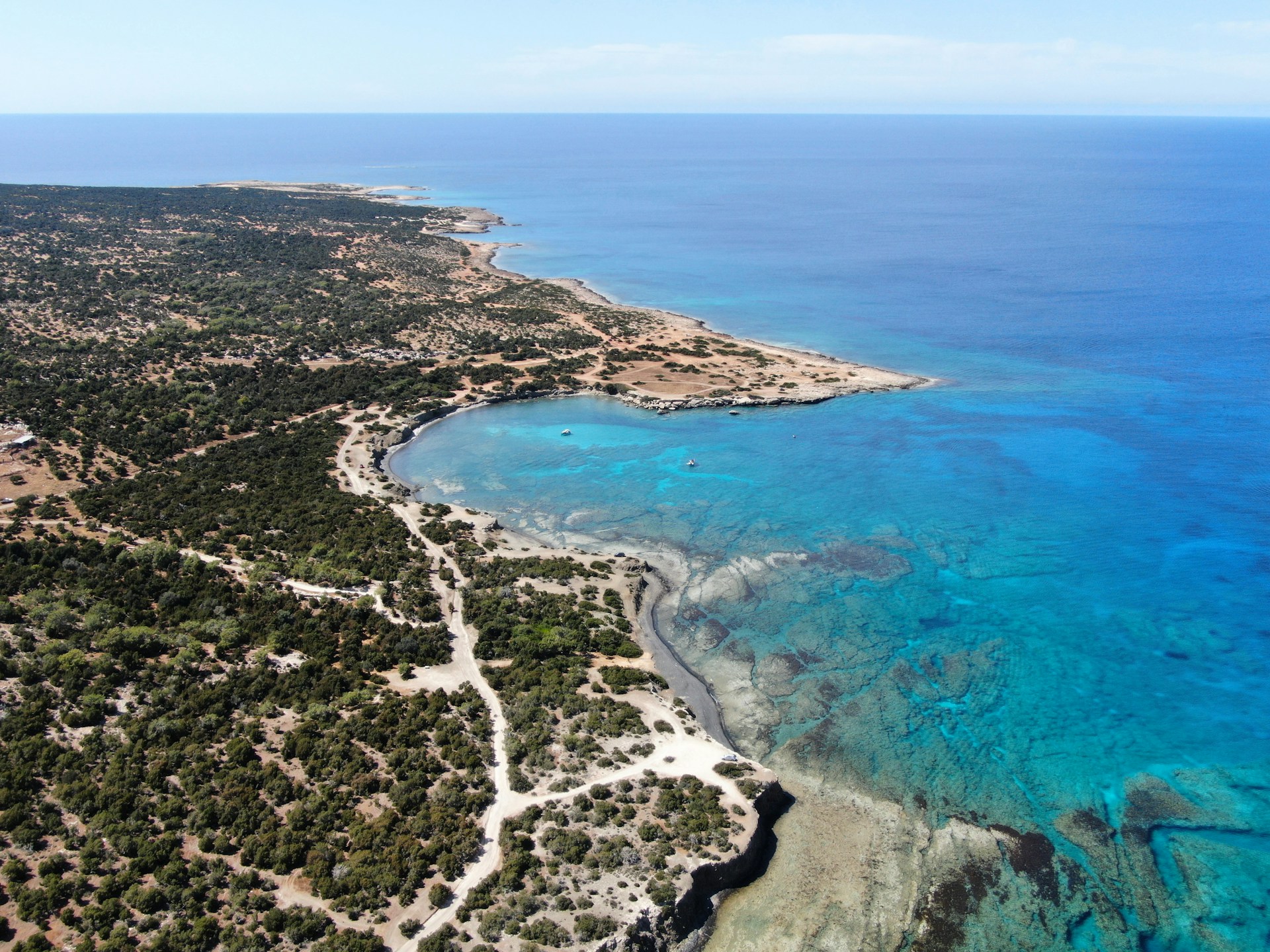 A breathtaking aerial view of the turquoise waters and rugged coastline of Costa Smeralda at sunset.
