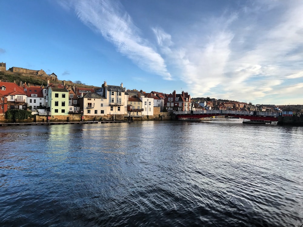 body of water near buildings under blue sky during daytime