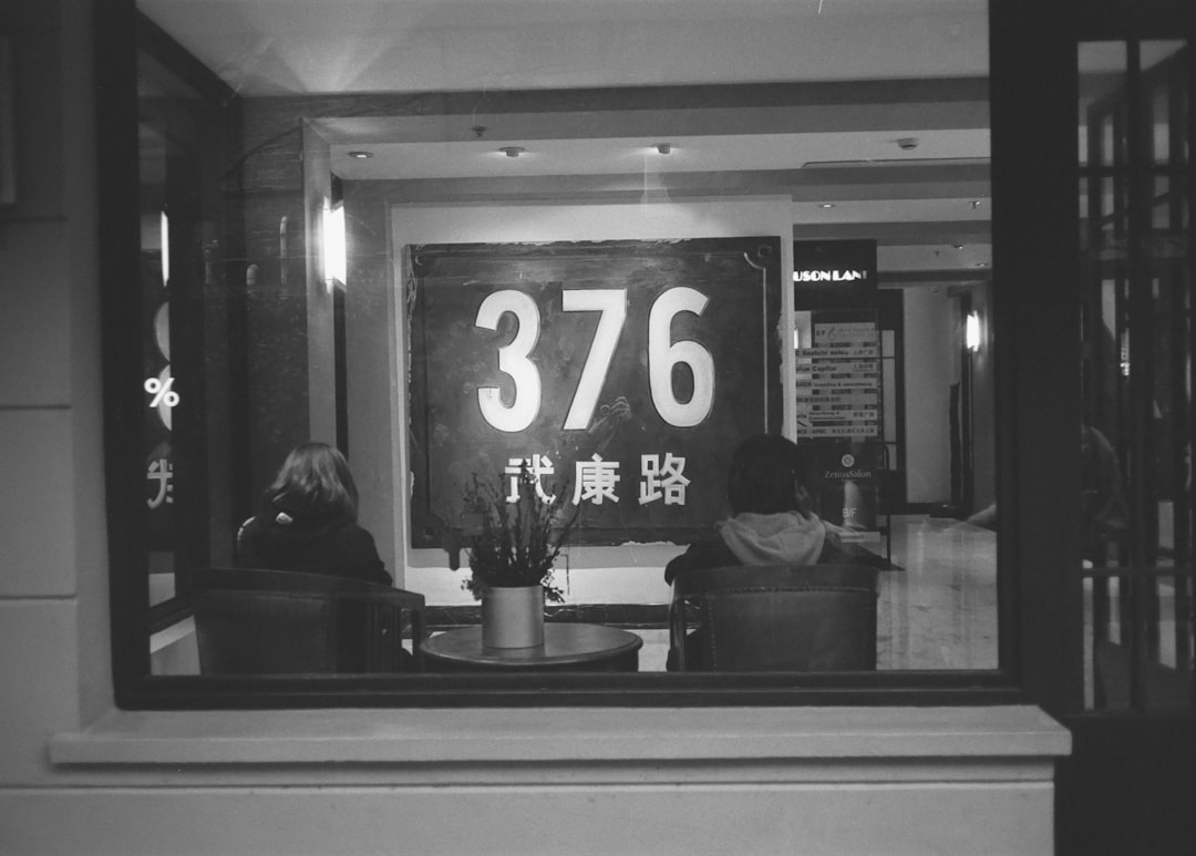 grayscale photo of man and woman sitting on chair