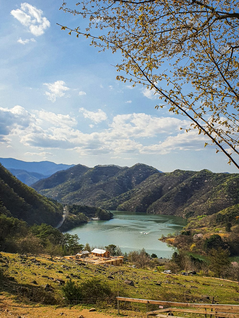 Montañas verdes cerca del lago bajo el cielo azul durante el día