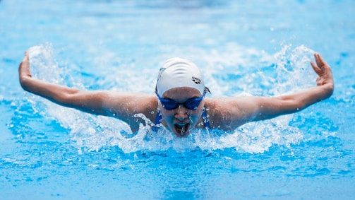 Children practicing swimming strokes under the guidance of a coach.