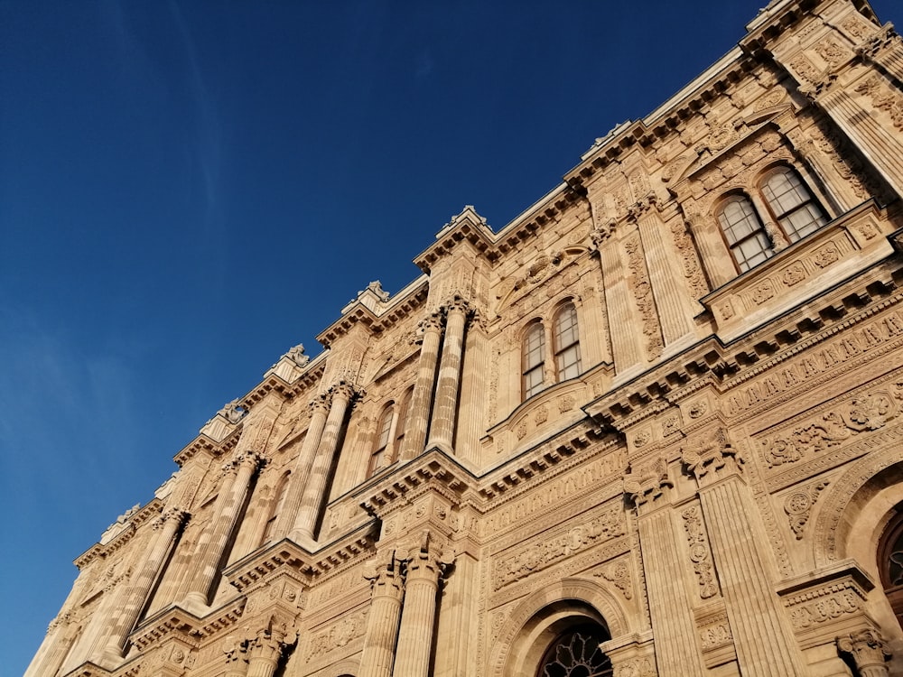 edificio in cemento marrone sotto il cielo blu durante il giorno