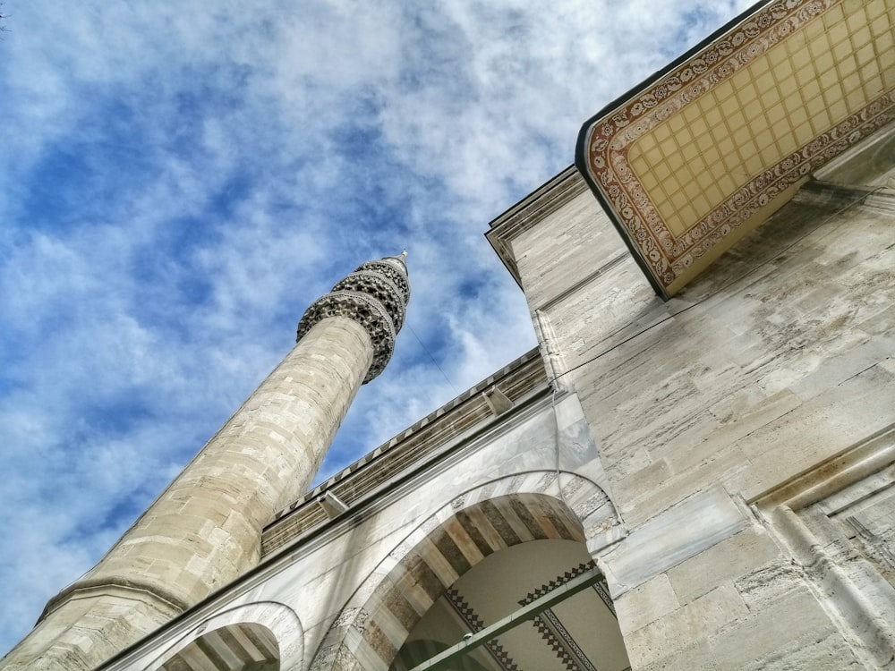 low angle photography of beige concrete building under blue sky during daytime