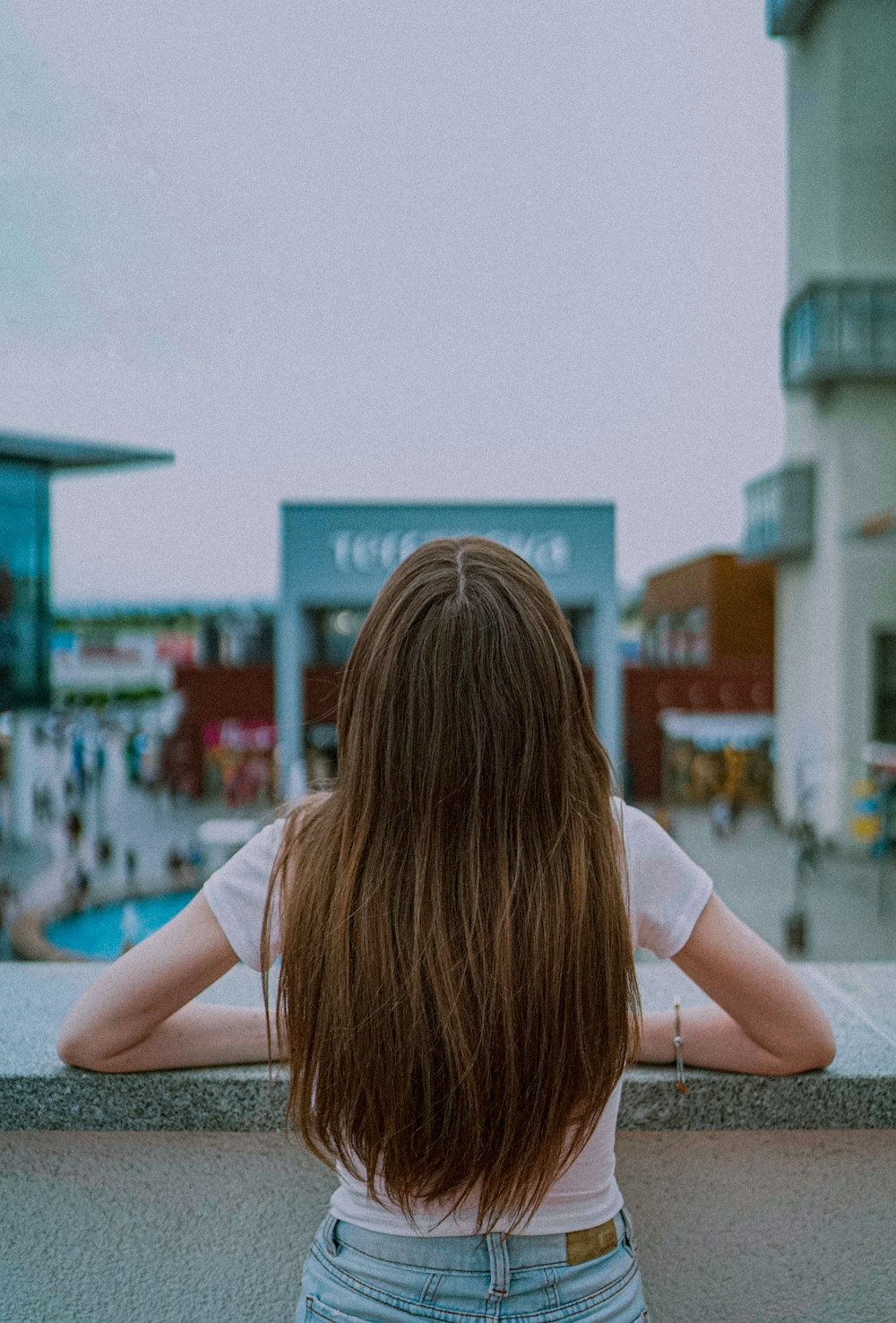 woman in white t-shirt sitting on concrete floor during daytime