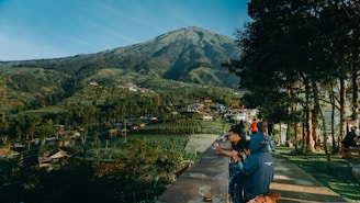 people walking on concrete bridge near mountain during daytime