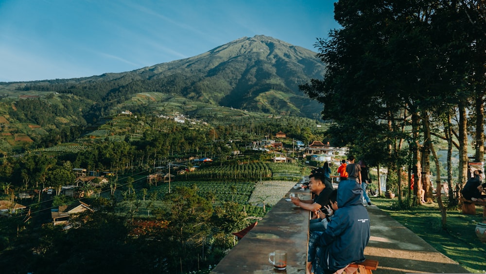 people walking on concrete bridge near mountain during daytime