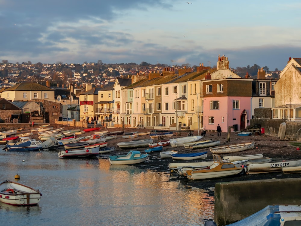 boats on dock near buildings during daytime