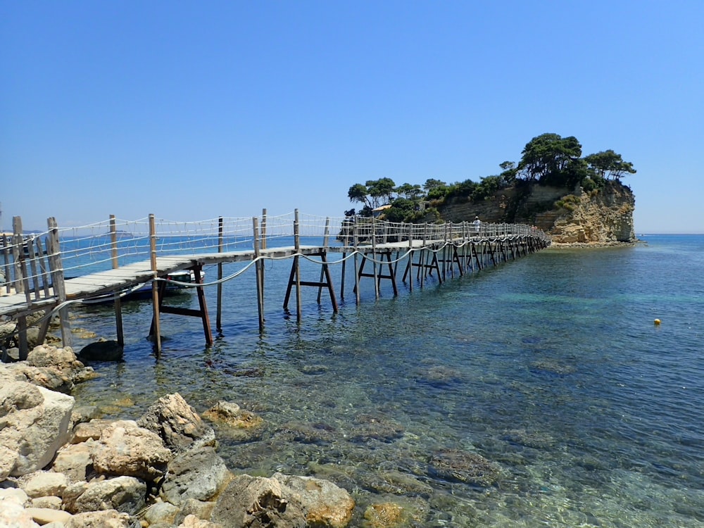 brown wooden dock on blue sea under blue sky during daytime