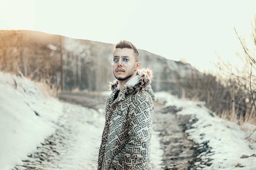 woman in black and white tribal coat standing on snow covered ground during daytime