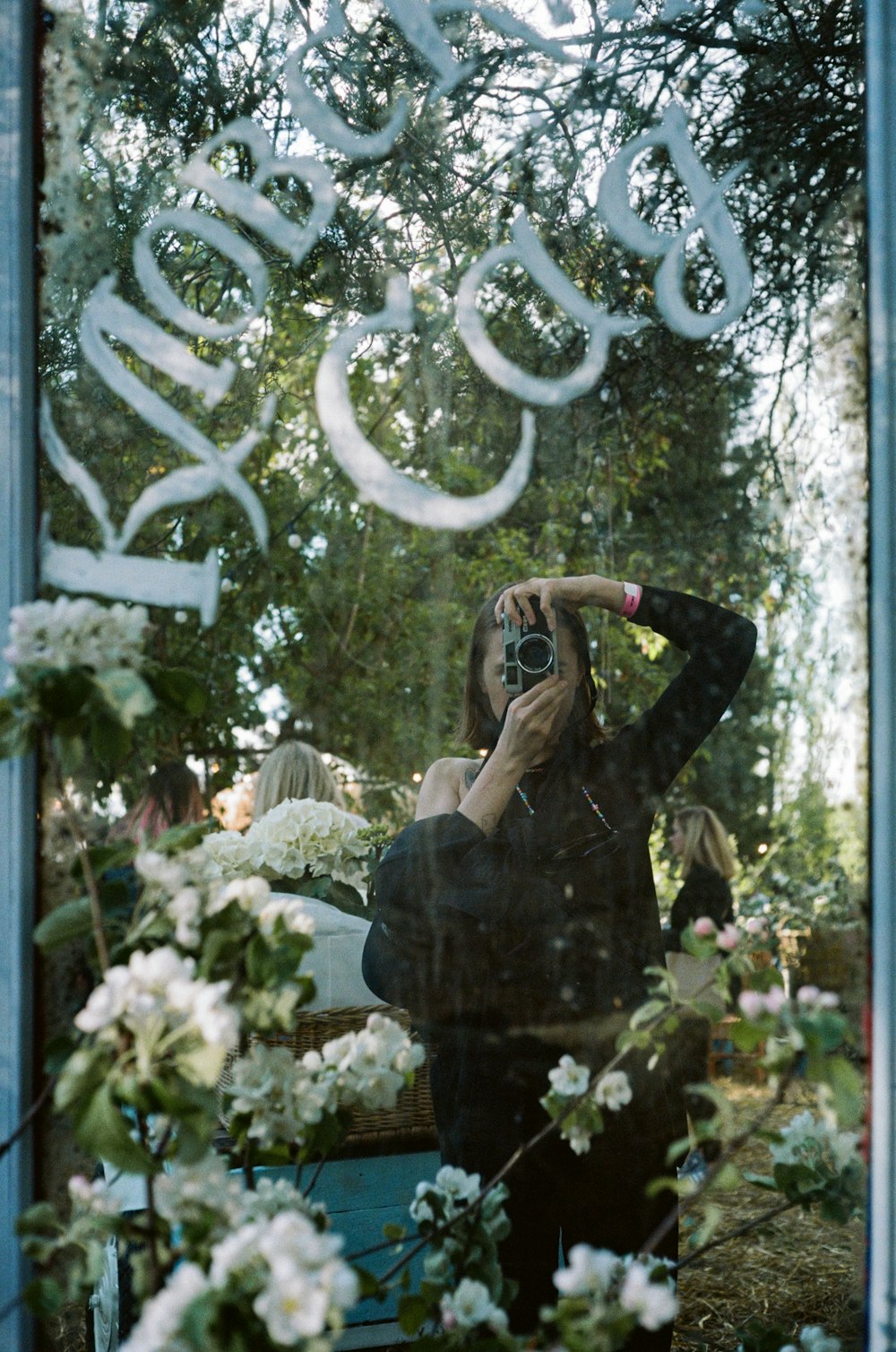 woman in black long sleeve shirt standing in front of white flowers