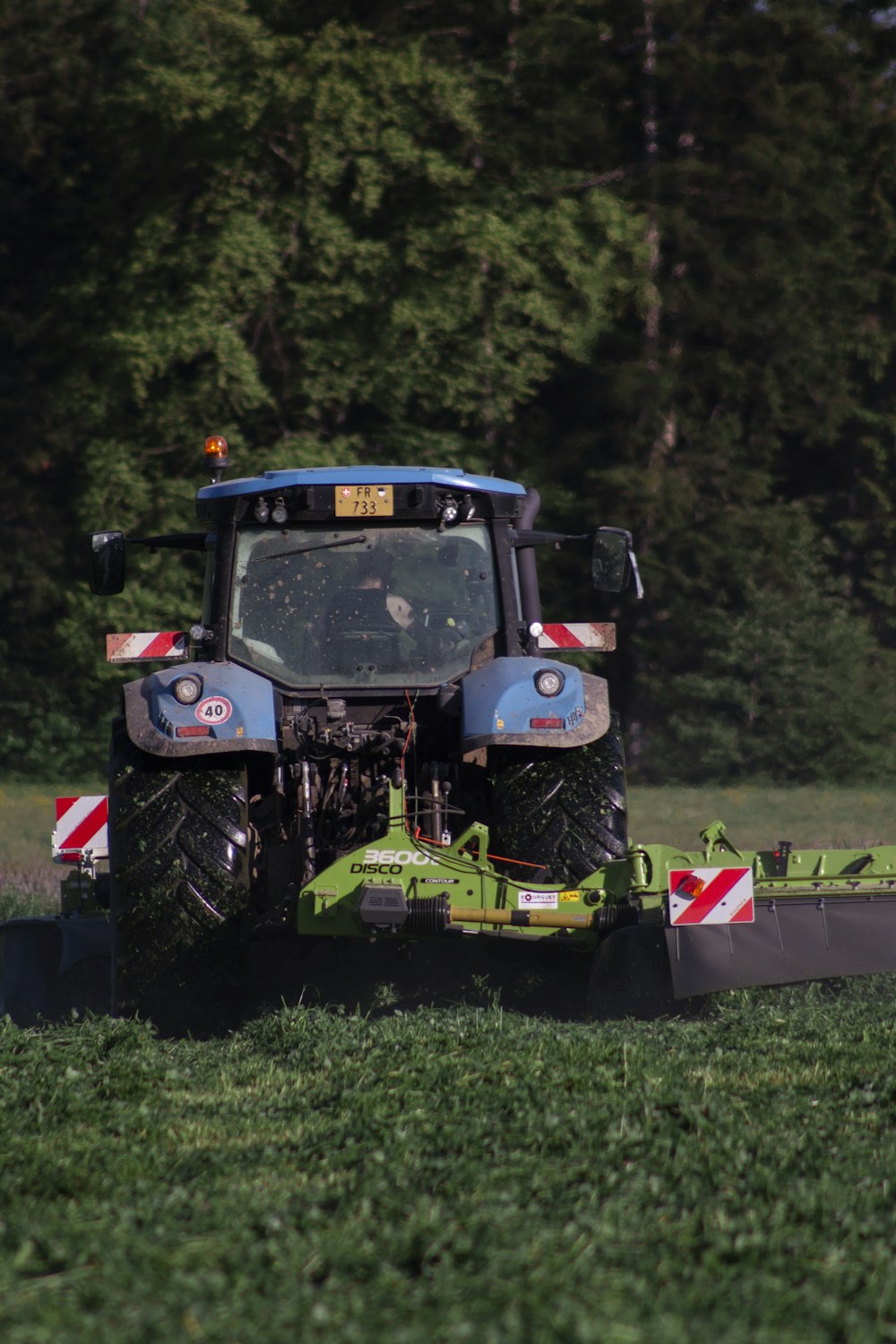 red and black tractor on green grass field during daytime