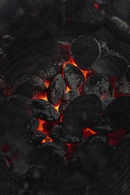Close-up of glowing charcoal briquettes ready for grilling