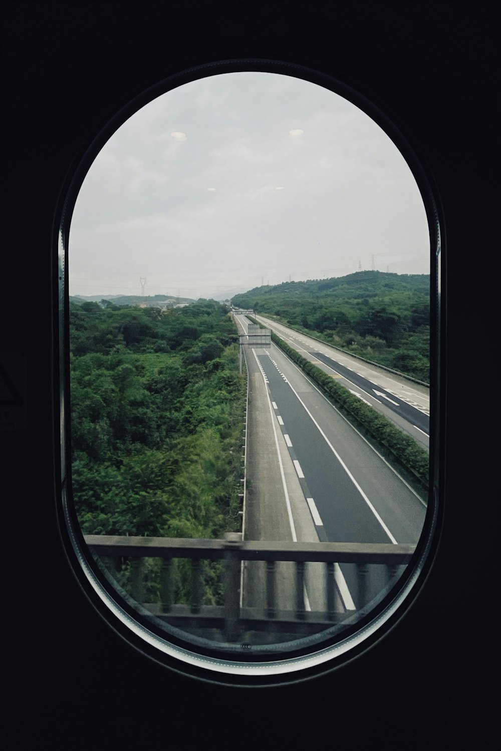 gray concrete road between green trees during daytime